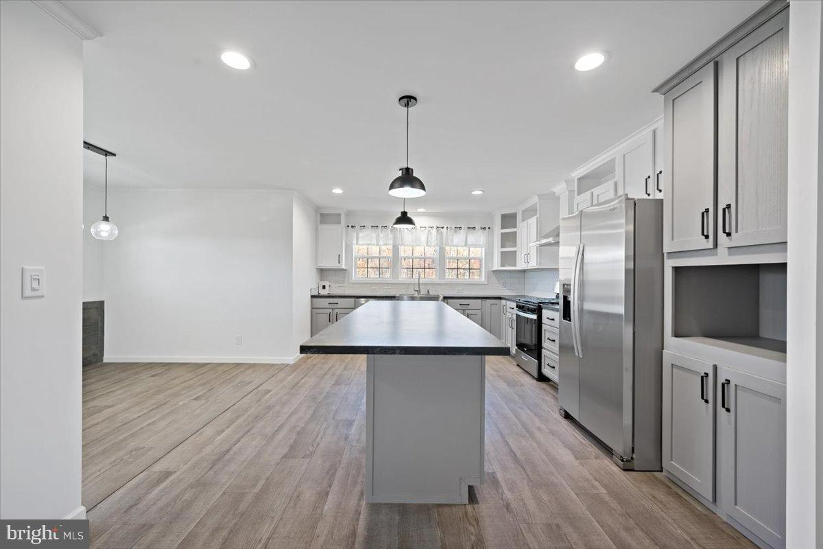 1412 Heytesbury Road Walnutport, PA 18088 - Photo 19 of 39 a view of a kitchen center island wooden floor cabinets and stainless steel appliances