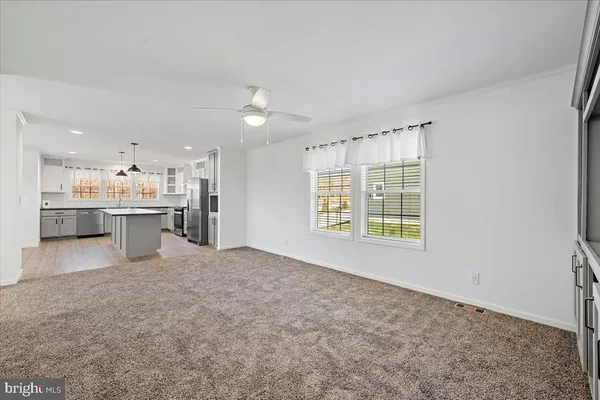 a view of an empty room with a kitchen