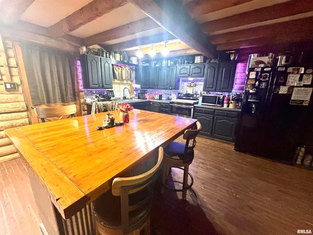 a kitchen with a table chairs and wooden floor