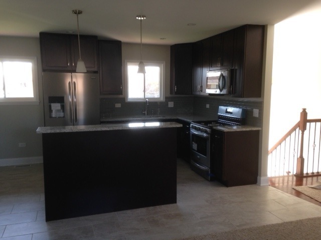 193 South Pinecrest Road Bolingbrook, IL 60440 - Photo 7 of 21 a kitchen with stainless steel appliances wooden cabinets a sink a stove and a refrigerator