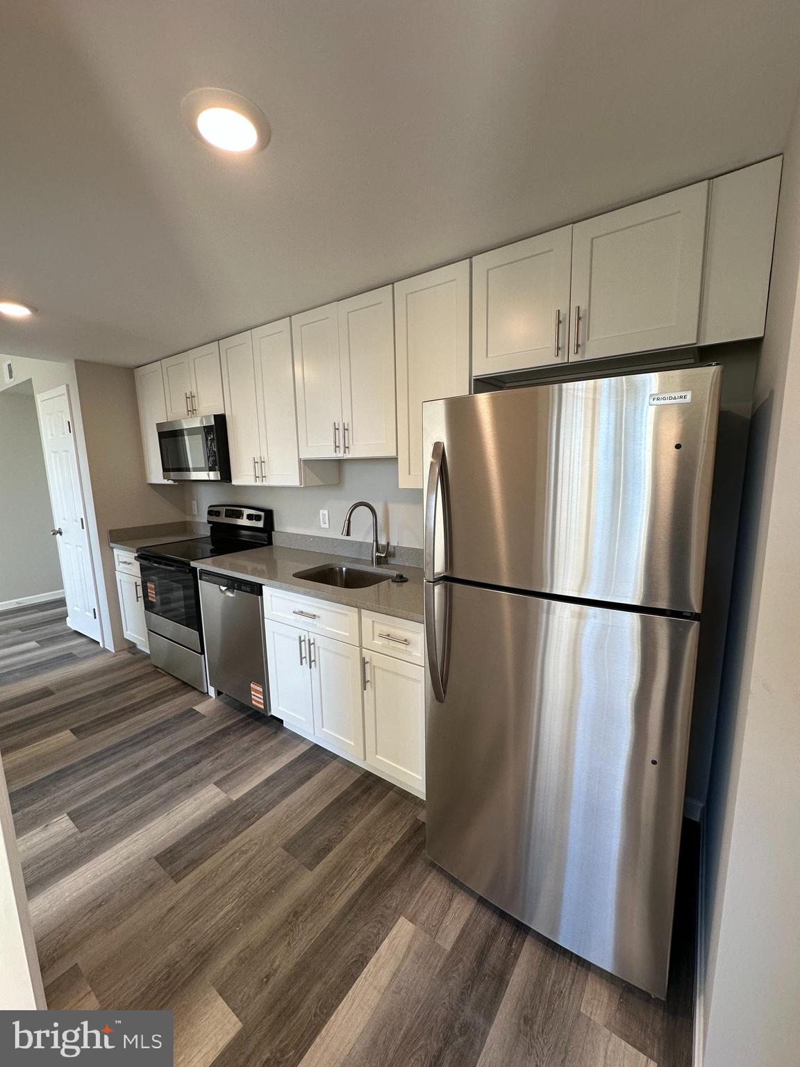 1812 H Place Northeast, Unit B02 Washington, DC 20002 - Photo 3 of 13 a kitchen with a refrigerator a stove top oven and cabinets