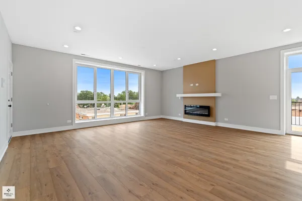 a view of empty room with wooden floor and fireplace