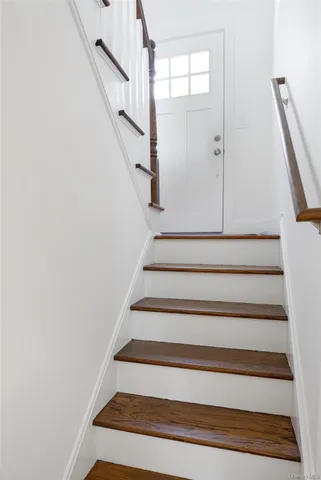 a view of empty room with wooden floor and fireplace