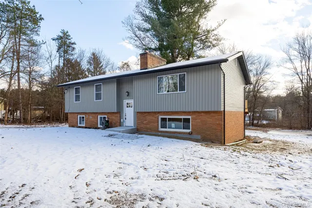 a view of a house with a yard covered in snow