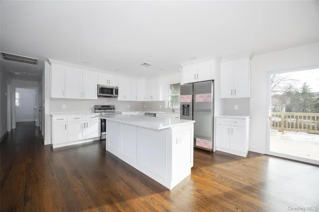 a kitchen with white cabinets and stainless steel appliances
