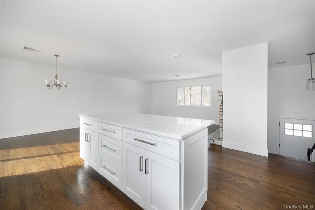 a kitchen with cabinets stainless steel appliances and wooden floor