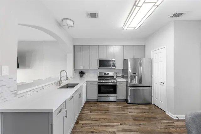 a kitchen with stainless steel appliances granite countertop a sink stove and refrigerator