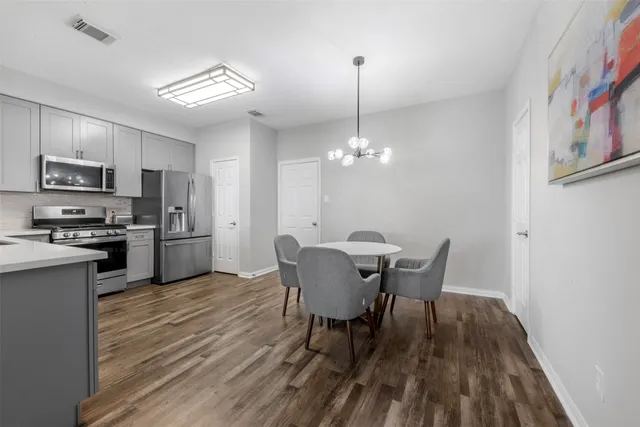 a view of a dining room with furniture a chandelier and wooden floor