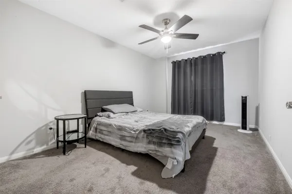 a bedroom with a bed a chandelier and a dresser