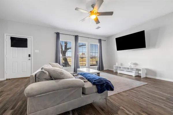 a bedroom with a bed a couch and a flat screen tv