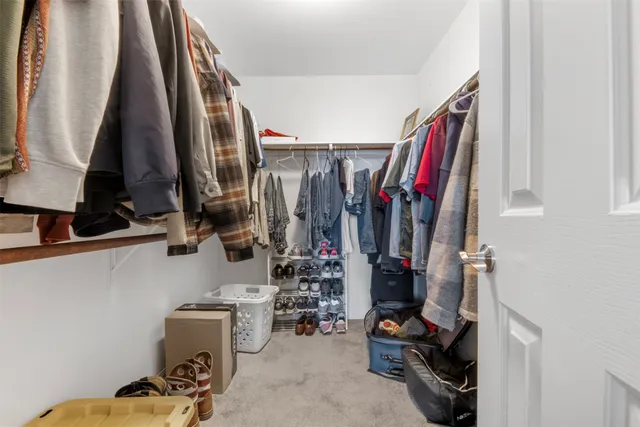 a view of walk in closet with clothes and shoes