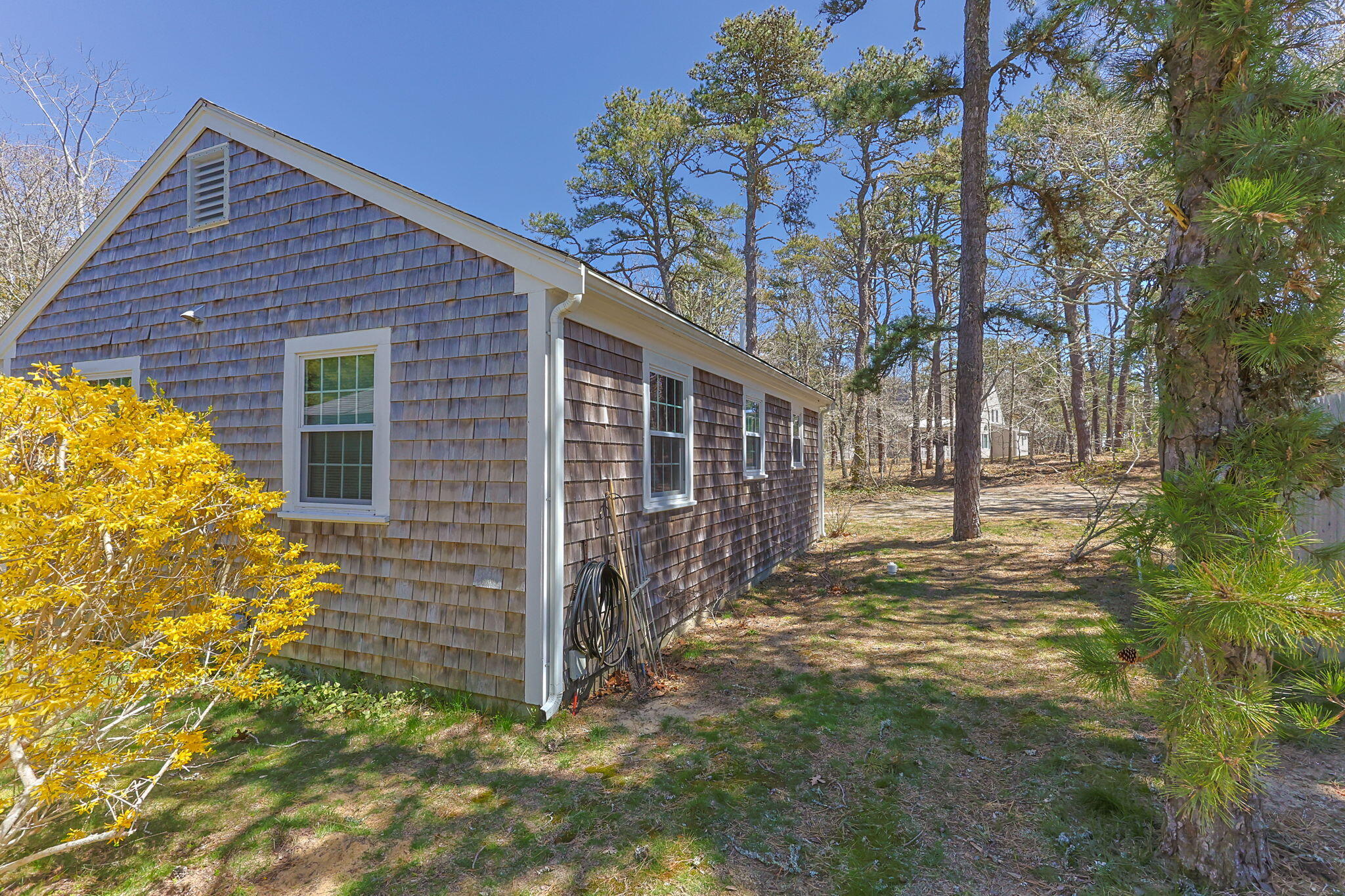 60 Long Avenue, Unit A Wellfleet, MA 02667 - Photo 2 of 28 a view of a house with a large tree and wooden fence