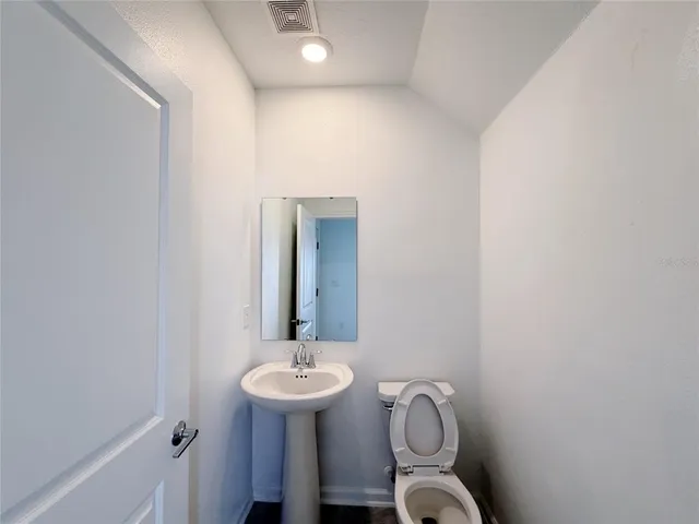 a view of kitchen with kitchen island granite countertop a stove a refrigerator a sink and a refrigerator