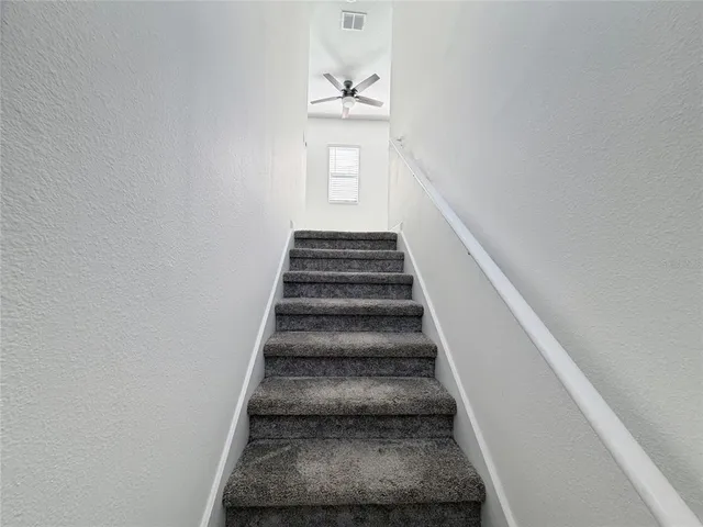 an empty room with a window and a ceiling fan