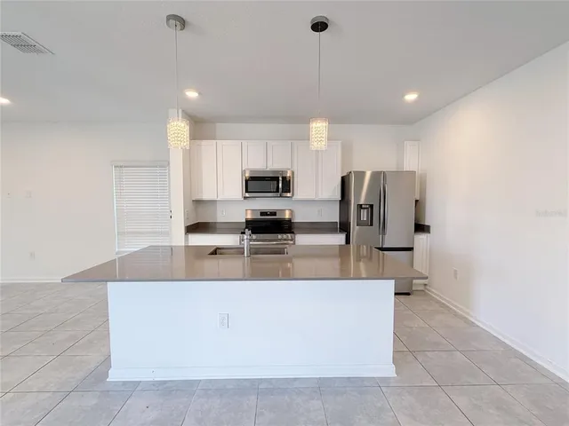 a kitchen with stainless steel appliances a refrigerator sink and microwave
