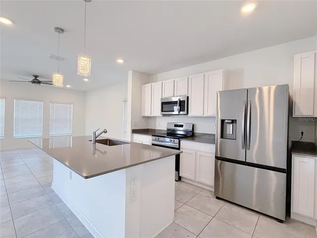 a kitchen with stainless steel appliances granite countertop a sink and a microwave