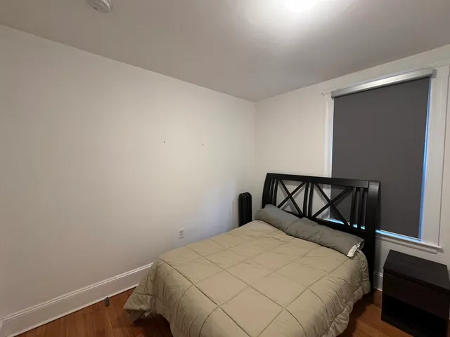 a bed sitting in a bedroom next to a window