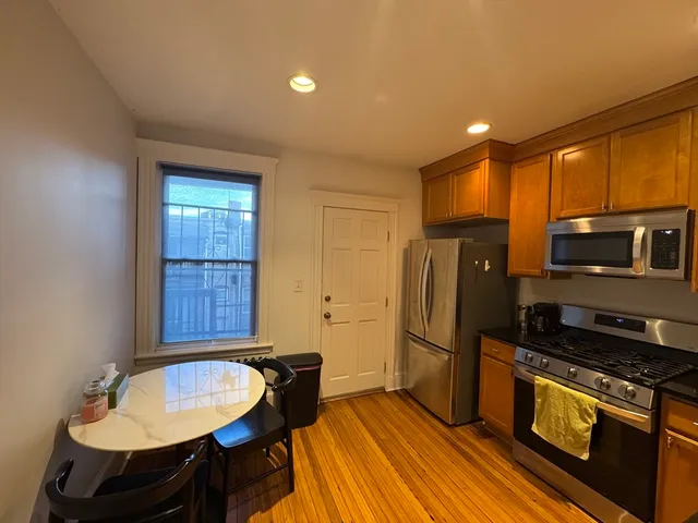 a kitchen with stainless steel appliances granite countertop a refrigerator a sink a stove and island