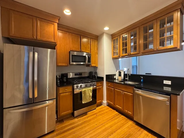 a kitchen with stainless steel appliances granite countertop a refrigerator stove top oven and sink