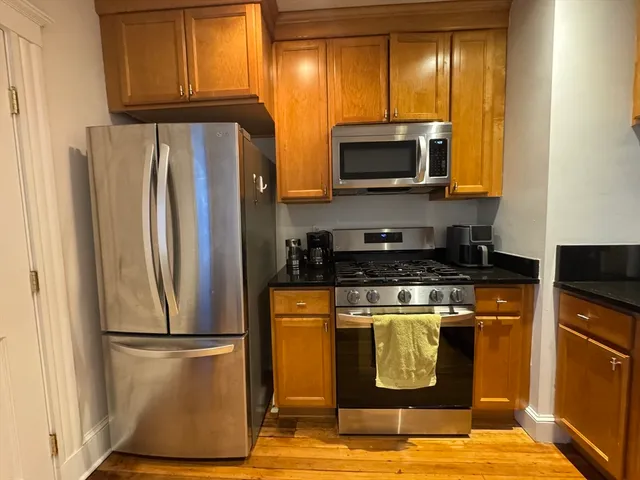 a kitchen with stainless steel appliances granite countertop a refrigerator and a stove top oven