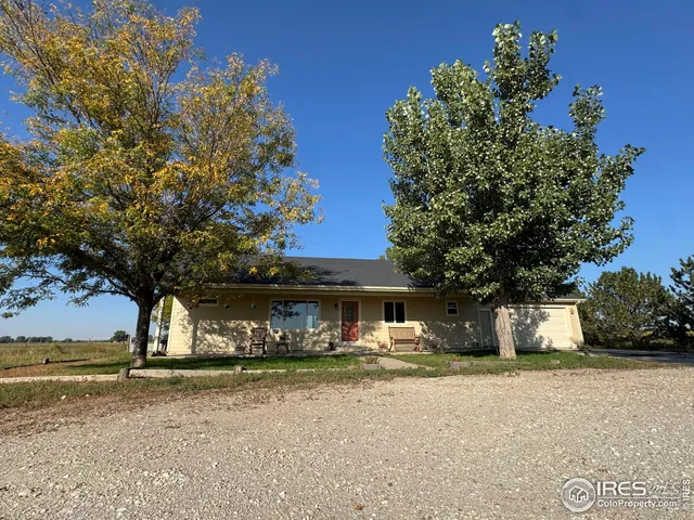 a front view of a house with a yard and tree s