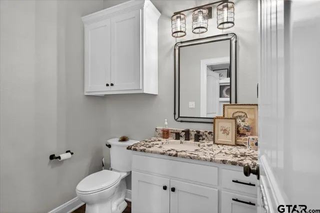 a bedroom with a bed ceiling fan and a wooden floor