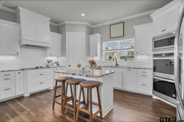 a kitchen with white cabinets and appliances
