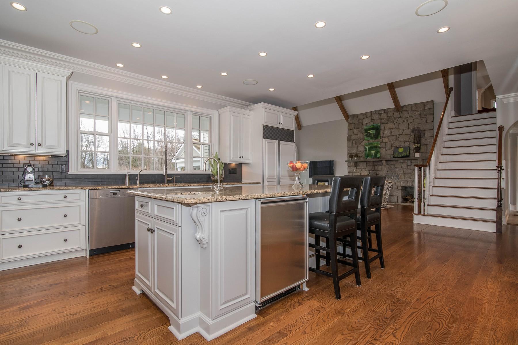 38 Pembroke Road Darien, CT 06820 - Photo 11 of 41 a kitchen with stainless steel appliances kitchen island granite countertop a table chairs sink and cabinets