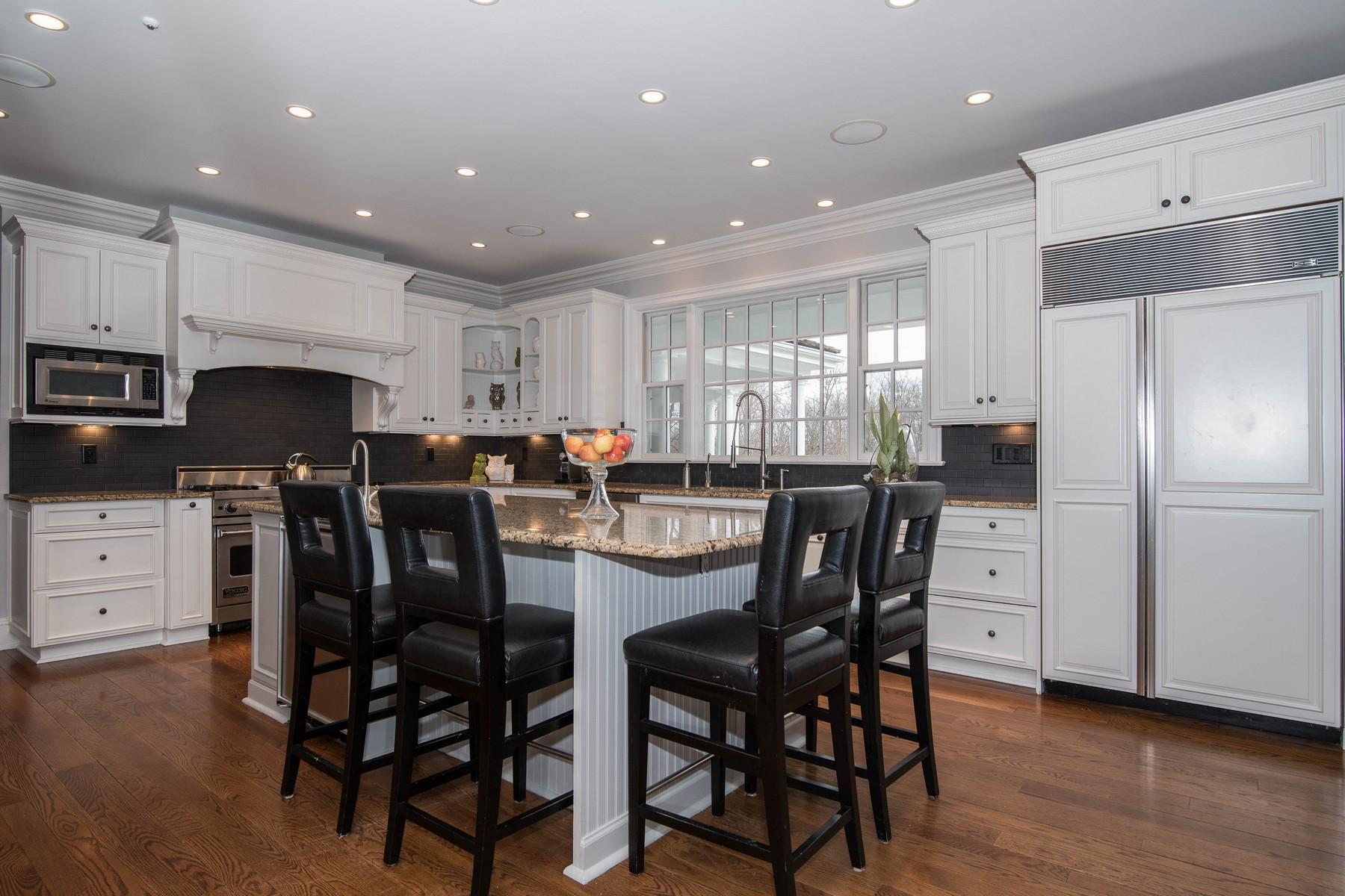 38 Pembroke Road Darien, CT 06820 - Photo 13 of 41 a kitchen with stainless steel appliances kitchen island granite countertop a dining table chairs refrigerator and sink