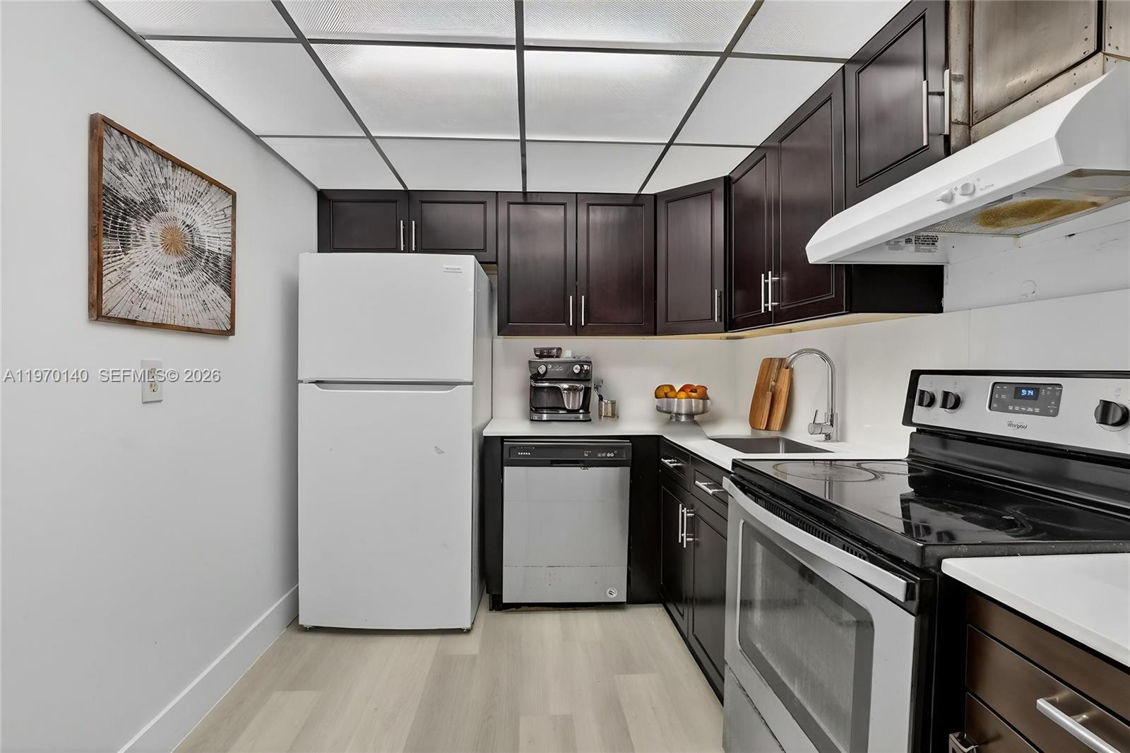 450 Northwest 20th Street, Unit 2120 Boca Raton, FL 33431 - Photo 17 of 27 a kitchen with stainless steel appliances a refrigerator a sink and wooden floors