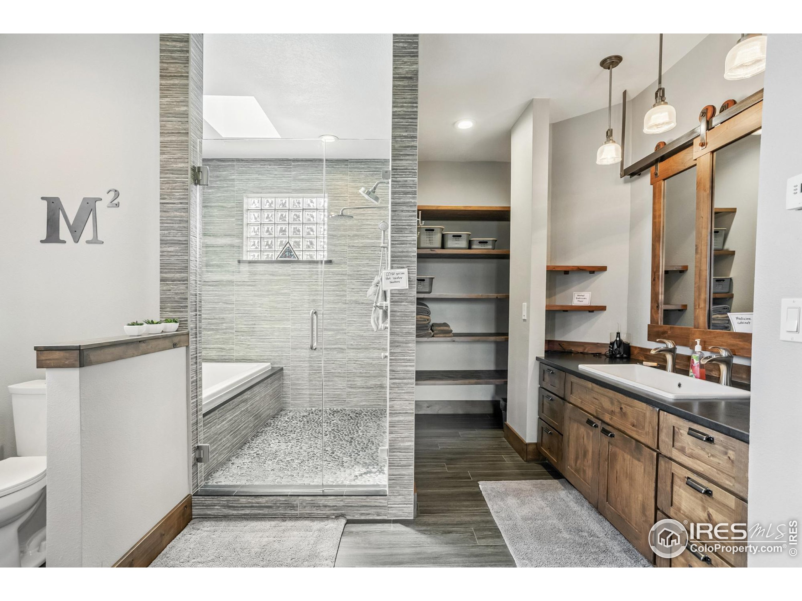 3310 Routt Street Wheat Ridge, CO 80033 - Photo 15 of 35 a bathroom with a double vanity sink a toilet a mirror and shower