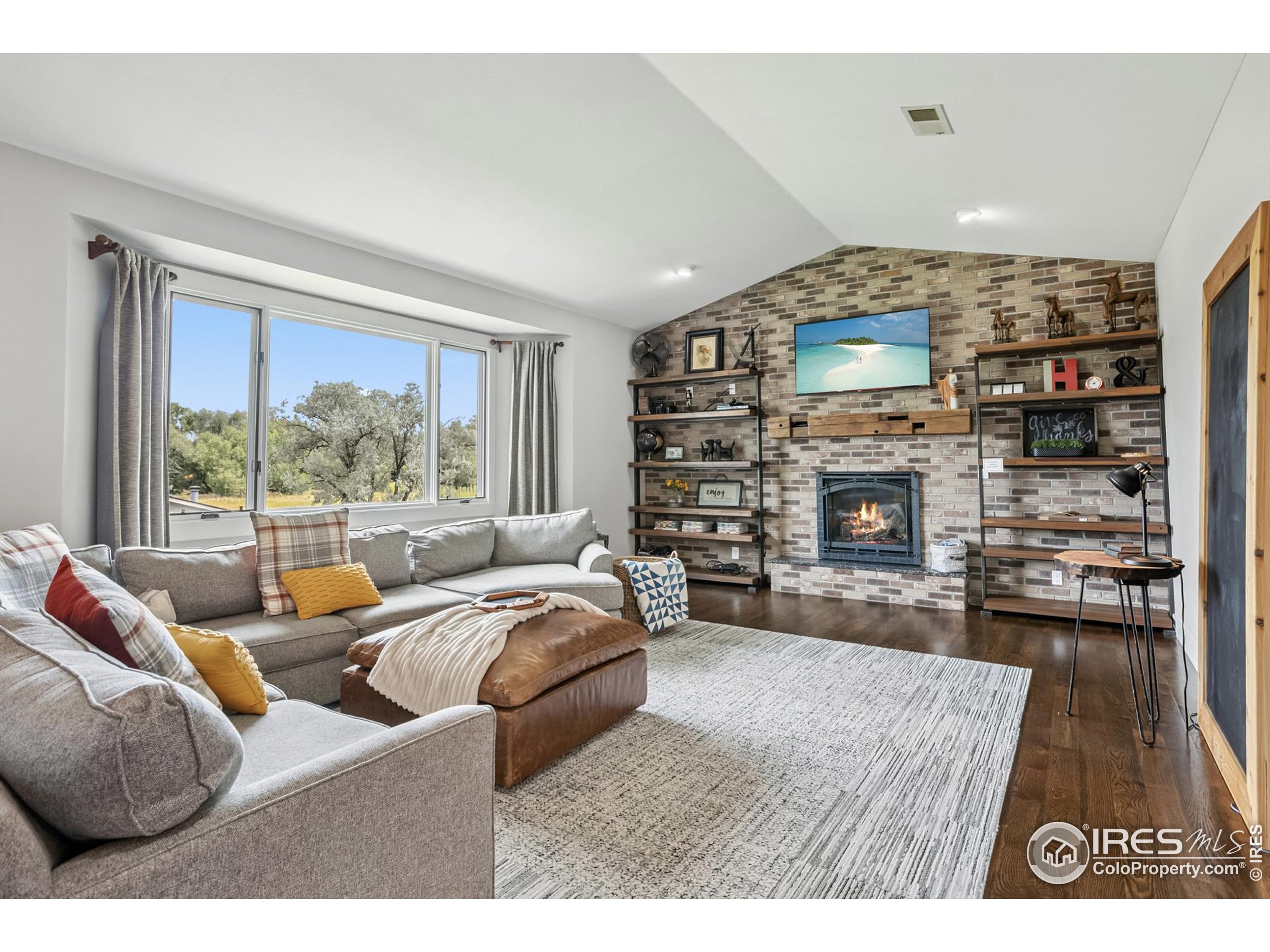 3310 Routt Street Wheat Ridge, CO 80033 - Photo 10 of 35 a living room with furniture a fireplace and a flat screen tv