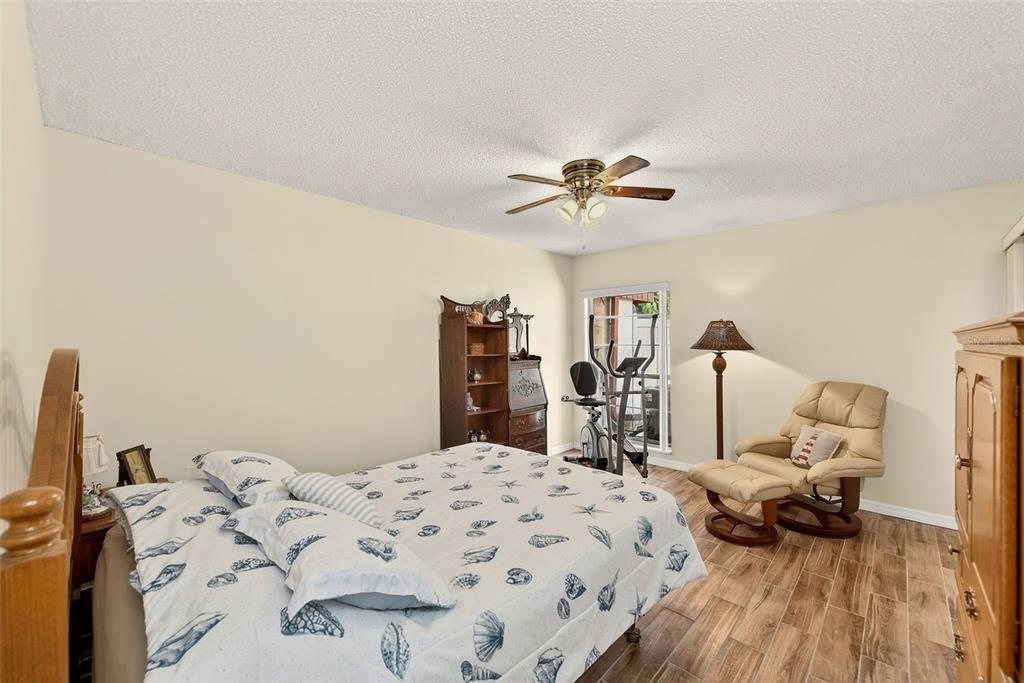 2064 Sunset Point Road, Unit 73 Clearwater, FL 33765 - Photo 25 of 58 a bedroom with a bed and wooden floor