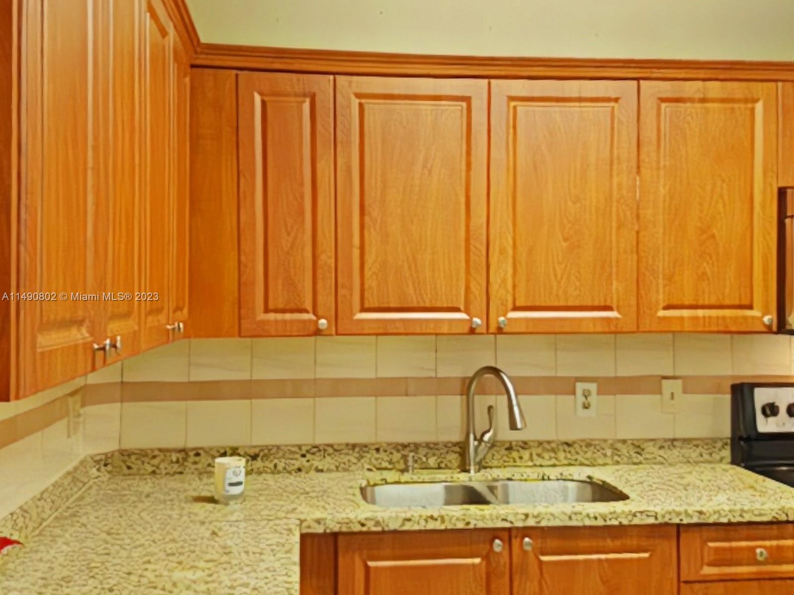 5643 Southwest 7th Street Miami, FL 33144 - Photo 18 of 25 a bathroom with a granite countertop sink and a mirror