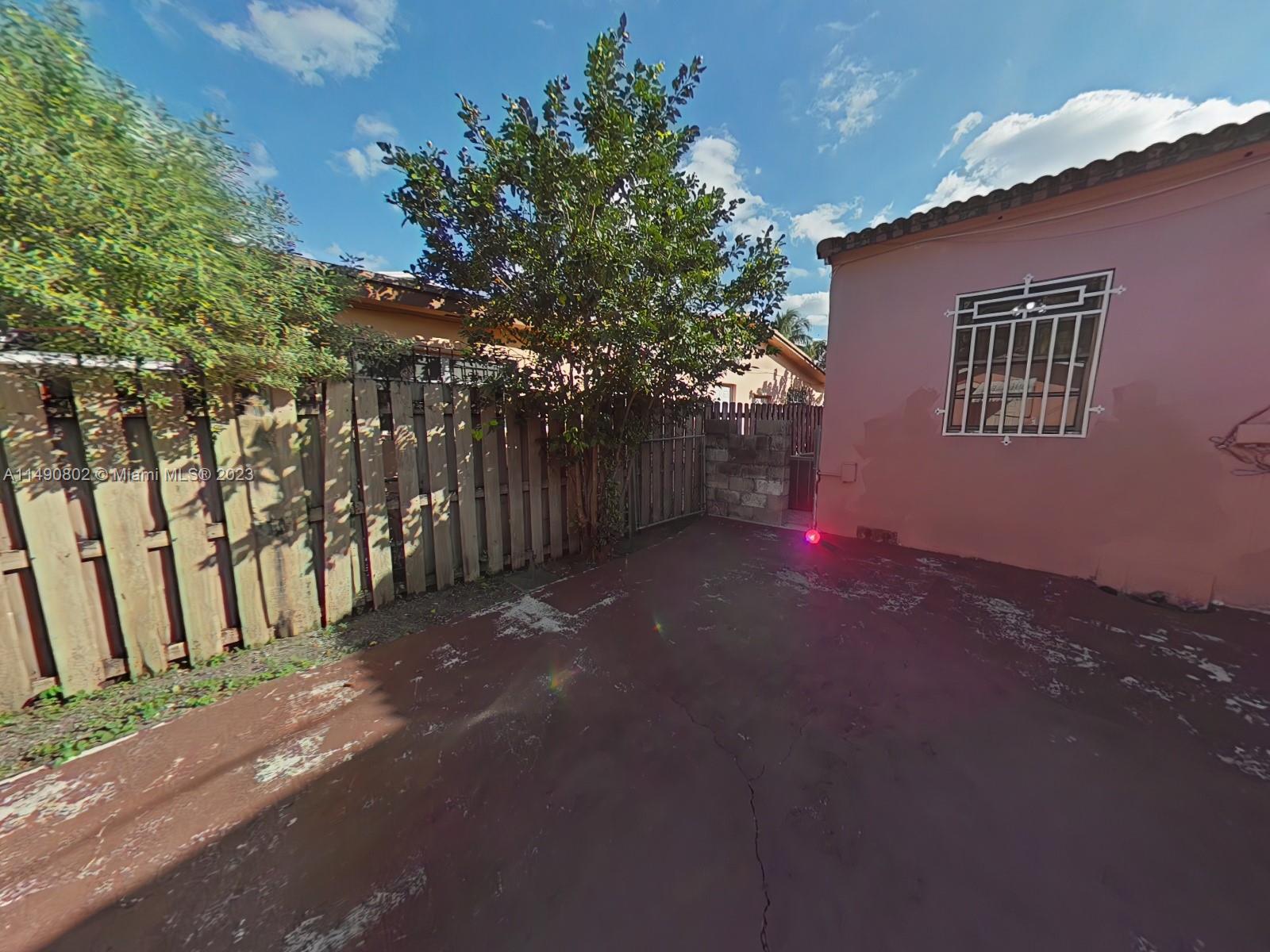 5643 Southwest 7th Street Miami, FL 33144 - Photo 22 of 25 a backyard of a house with table and chairs
