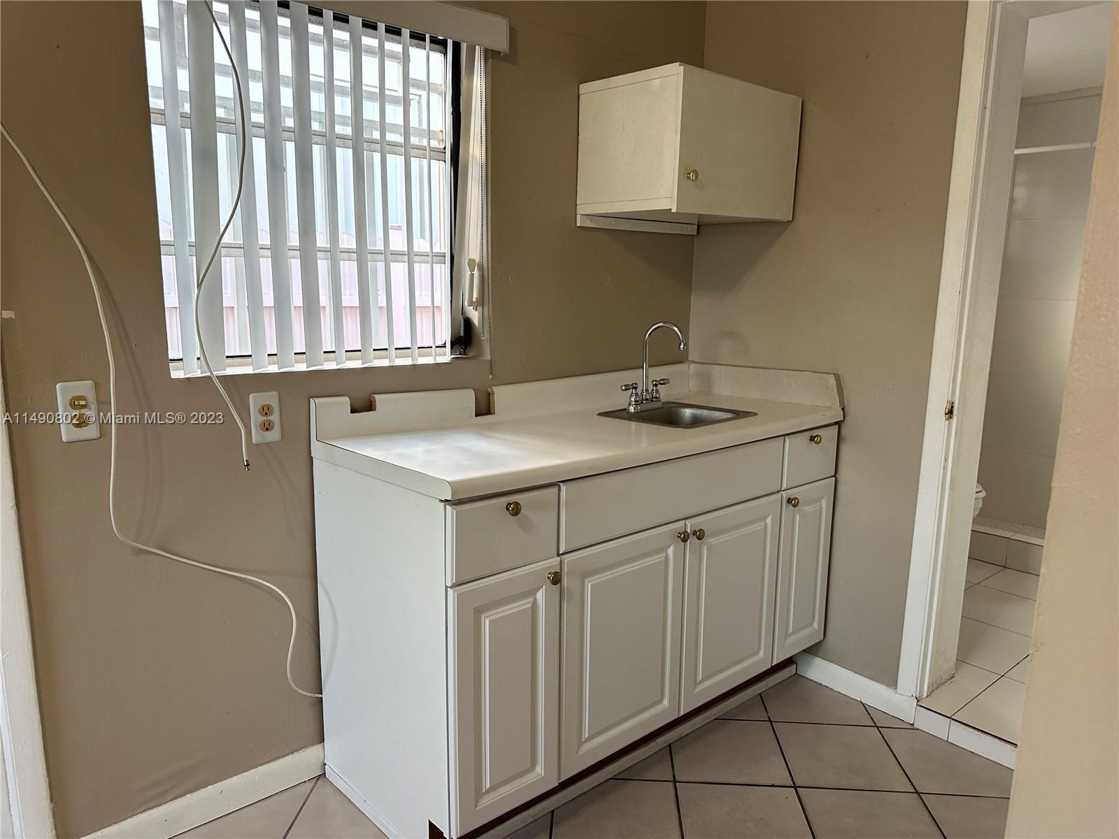 5643 Southwest 7th Street Miami, FL 33144 - Photo 8 of 25 a bathroom with a sink and a mirror