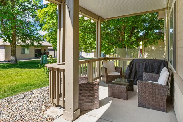 a view of a patio with couches chairs potted plants and tree