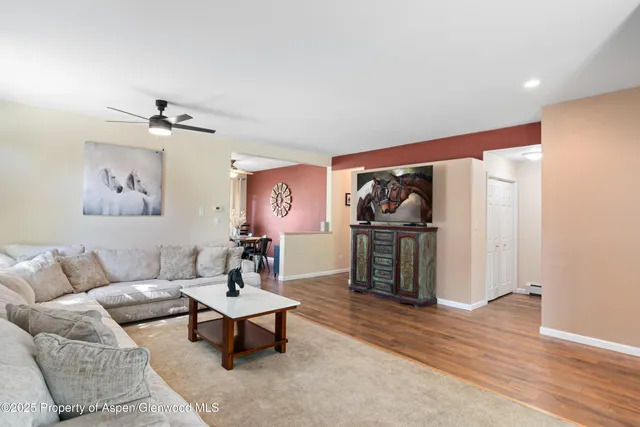 a living room with furniture and a ceiling fan