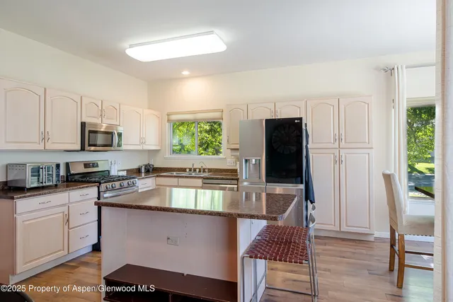 a kitchen with stainless steel appliances granite countertop a stove refrigerator sink and cabinets