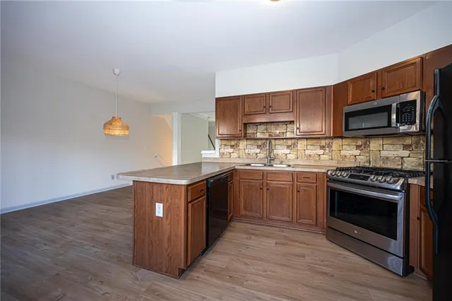 a kitchen with stainless steel appliances granite countertop a stove a sink and a microwave