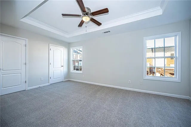an empty room with fan and windows