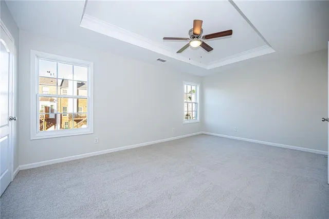 an empty room with window and ceiling fan