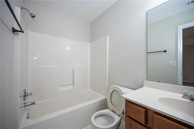 a bathroom with a sink toilet vanity and shower