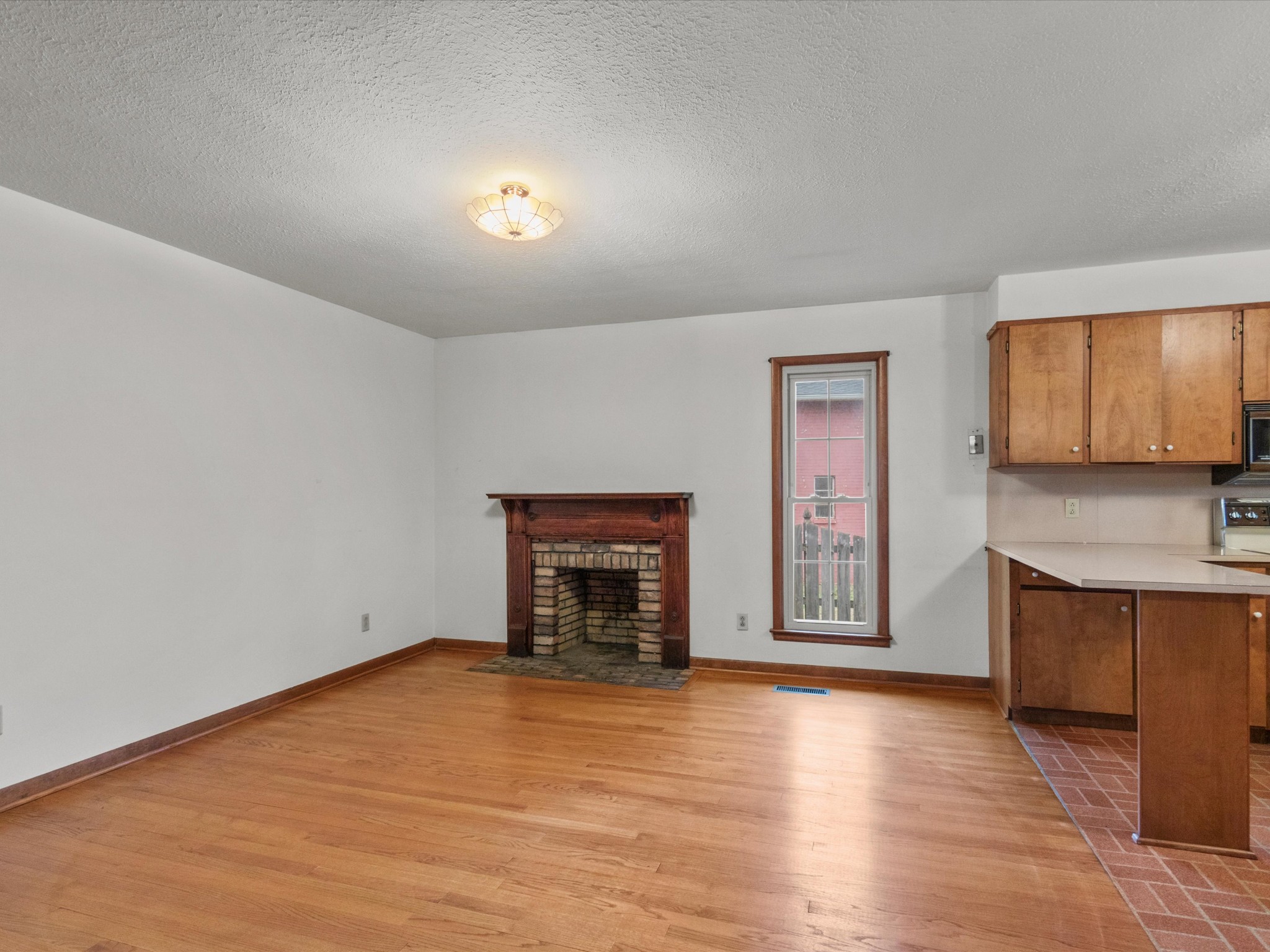 715 South Clinton Street Athens, AL 35611 - Photo 39 of 63 an empty room with a fireplace and wooden floor