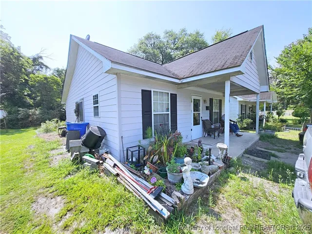 a view of a house with backyard sitting area and garden