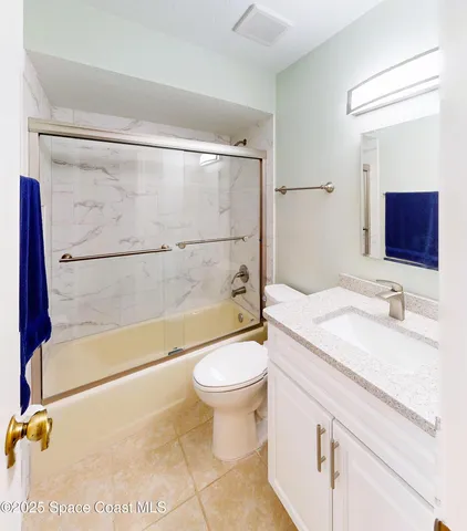 a bathroom with a sink and mirror with bathtub