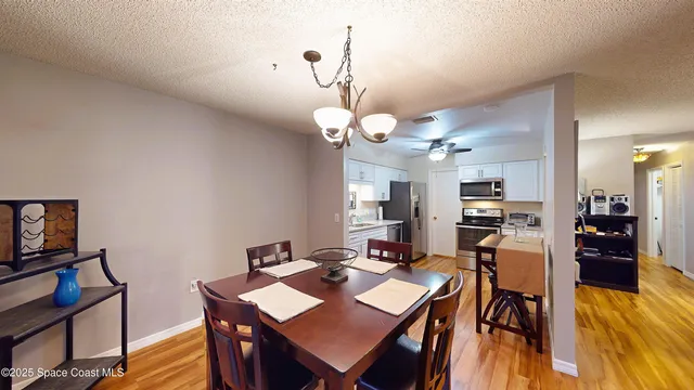 a kitchen with stainless steel appliances a stove a sink a refrigerator a microwave oven with cabinets and wooden floor