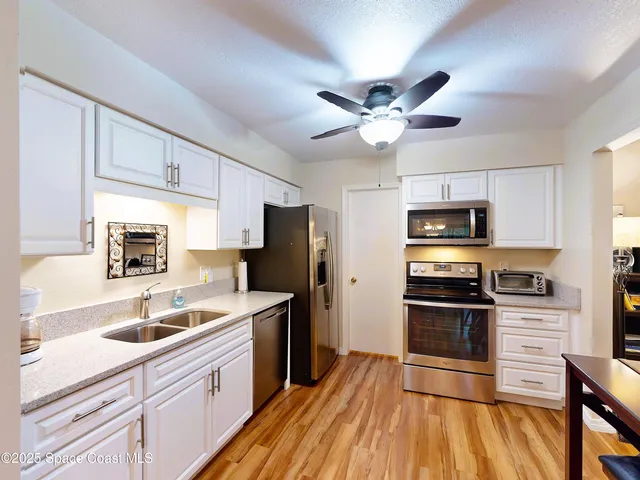 a kitchen with a refrigerator sink and cabinets