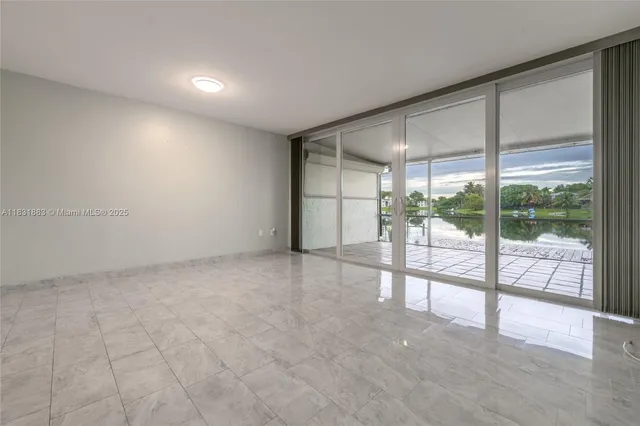 a view of an empty room with wooden floor and a sliding door