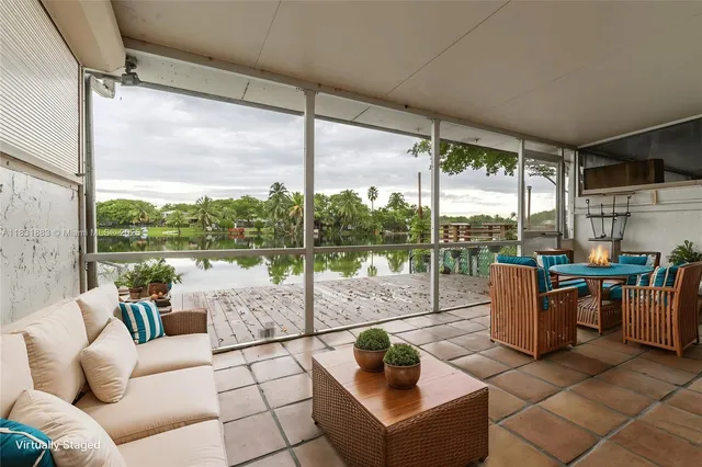 a living room with patio furniture and a garden